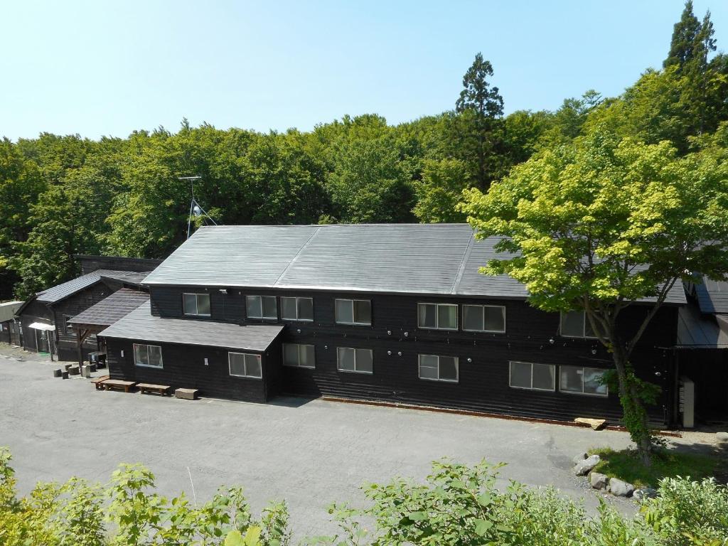ein großes schwarzes Gebäude mit vielen Fenstern in der Unterkunft Yachi Onsen in Towada