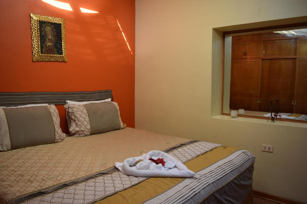 Un dormitorio con una cama con una toalla. en CASA RISO Cusco I, en Cusco