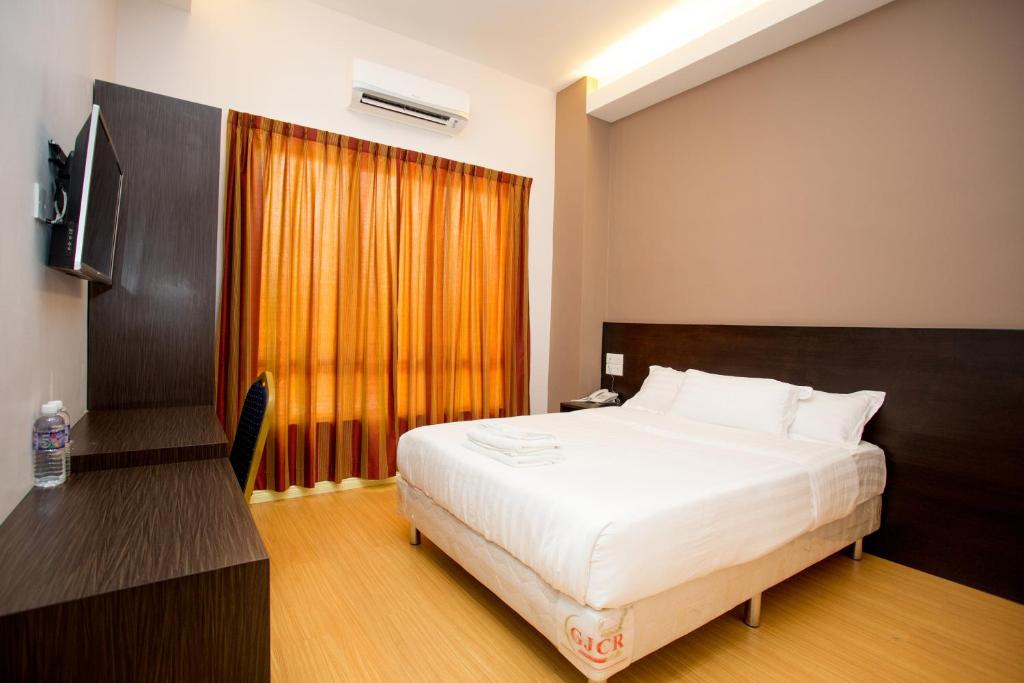 Postel nebo postele na pokoji v ubytování Labuan Fortune Hotel