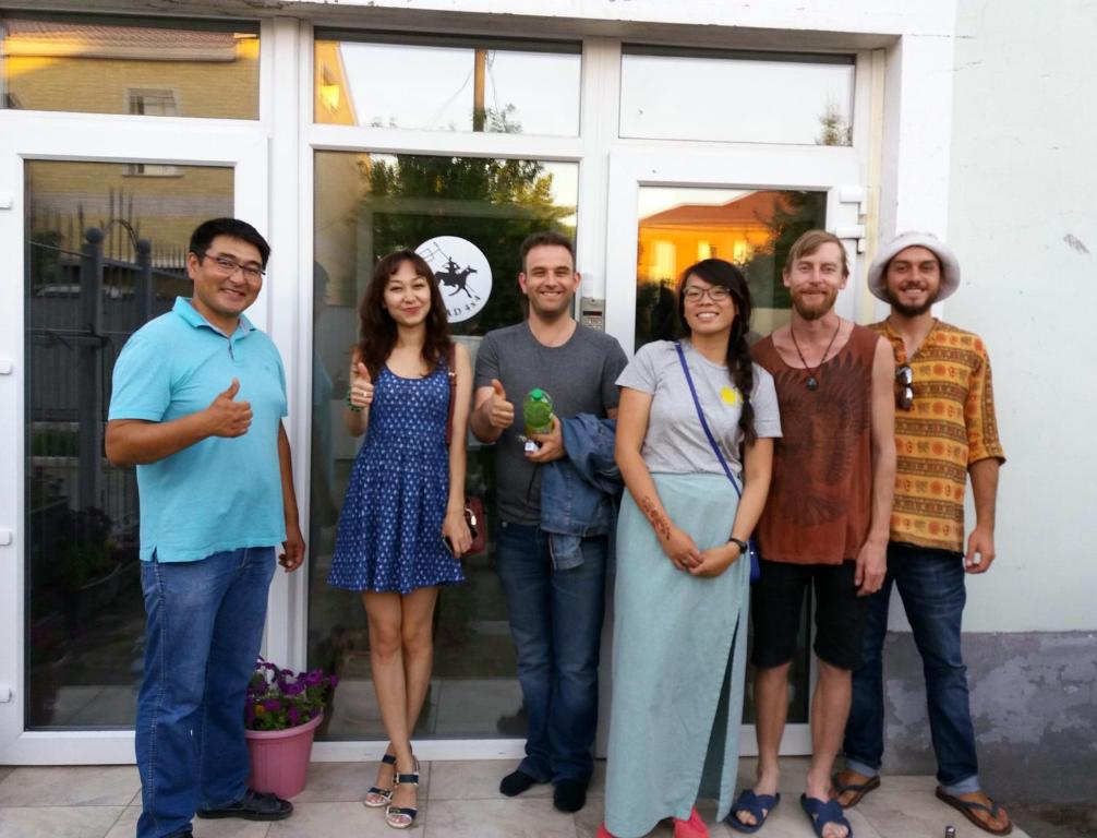 a group of people standing in front of a house at Hostel Nomad 4x4 in Astana