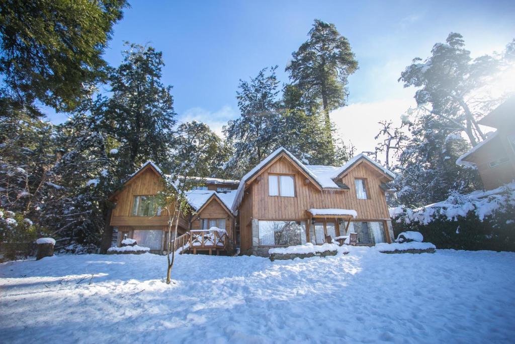 una casa in legno con neve per terra di Allá Ité a San Carlos de Bariloche