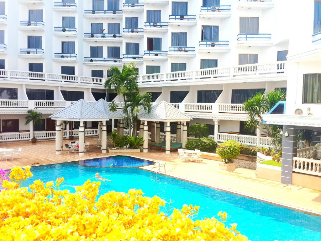 a swimming pool in front of a building at Caesar Palace Hotel in Pattaya