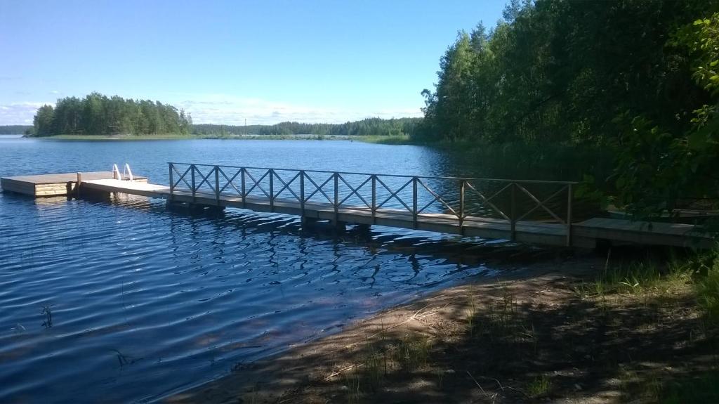 a dock in the middle of a lake at Kuvalusdream Chalet in Lintusalo