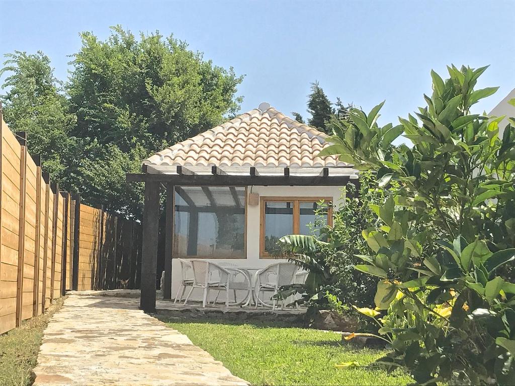 a backyard with a gazebo with chairs and a fence at Sol de Bolonia 5 in Bolonia