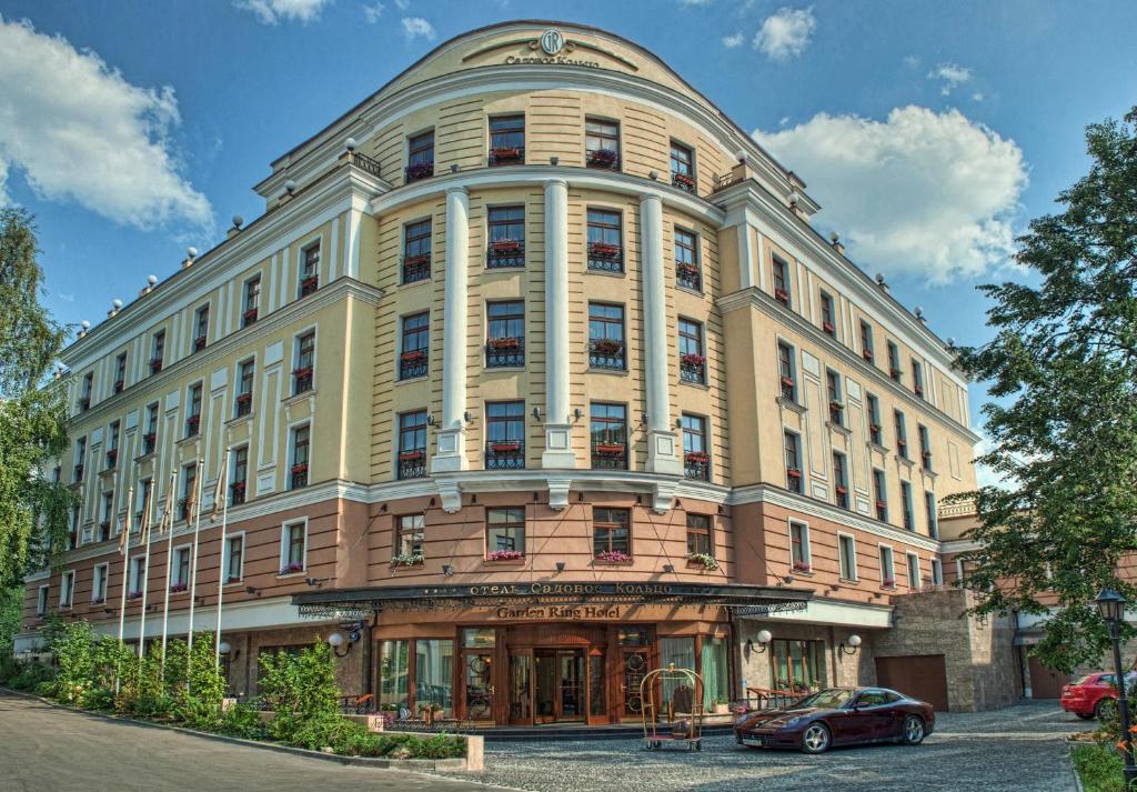فندق جاردن رينج في موسكو: مبنى كبير فيه سيارة متوقفة أمامه