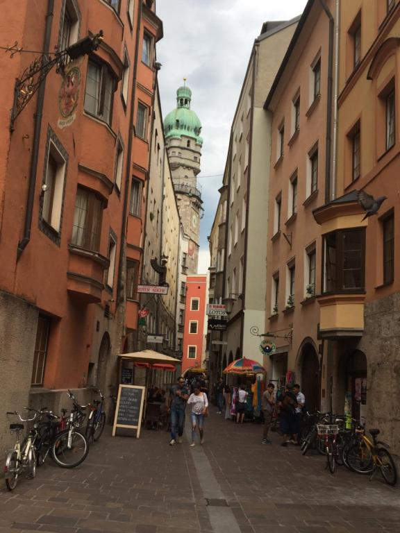 a group of people walking down a street with buildings at Mariposa in Innsbruck