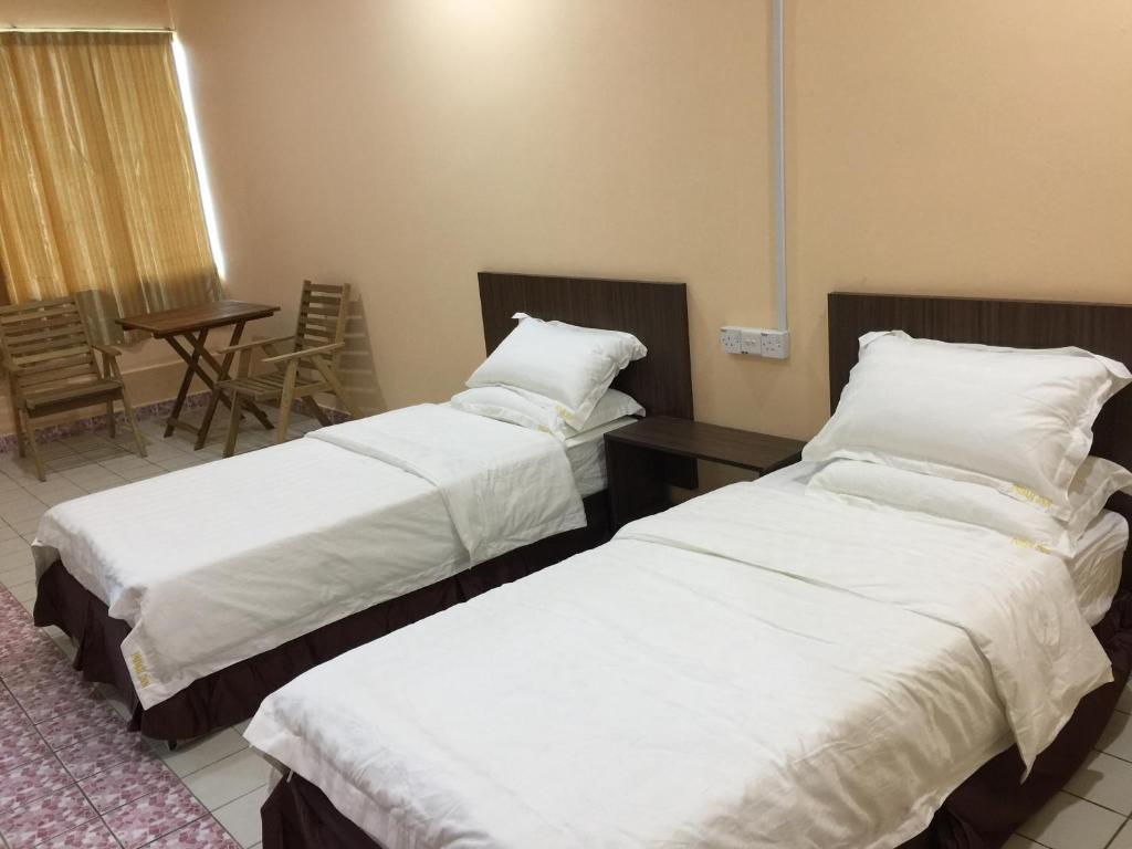 Postel nebo postele na pokoji v ubytování Indah Inn