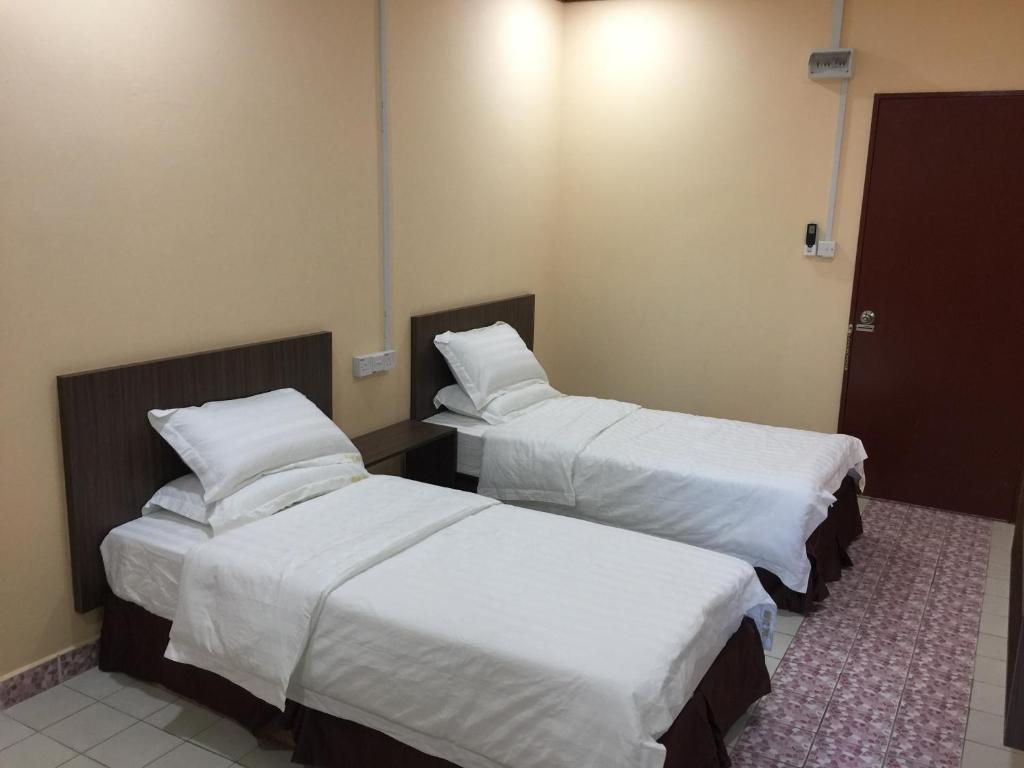 Postel nebo postele na pokoji v ubytování Indah Inn