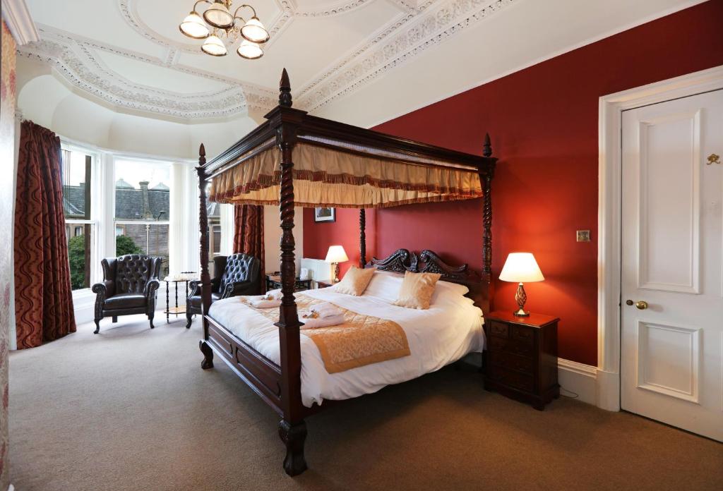 1 dormitorio con cama con dosel y paredes rojas en Ard Na Said, en Edimburgo