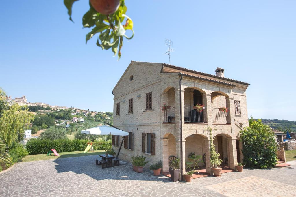 een groot stenen gebouw met een balkon en een paraplu bij Bed and breakfast Aratro & Rosmarino in Civitanova Marche