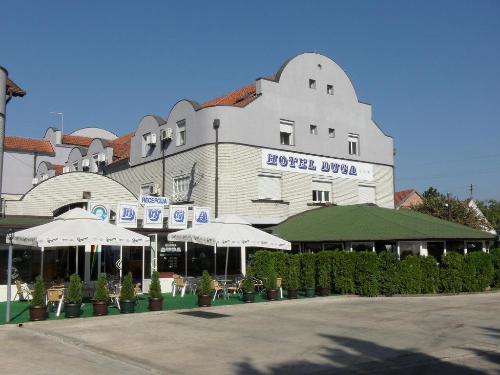 un gran edificio con sombrillas delante en Hotel Duga, en Novi Sad