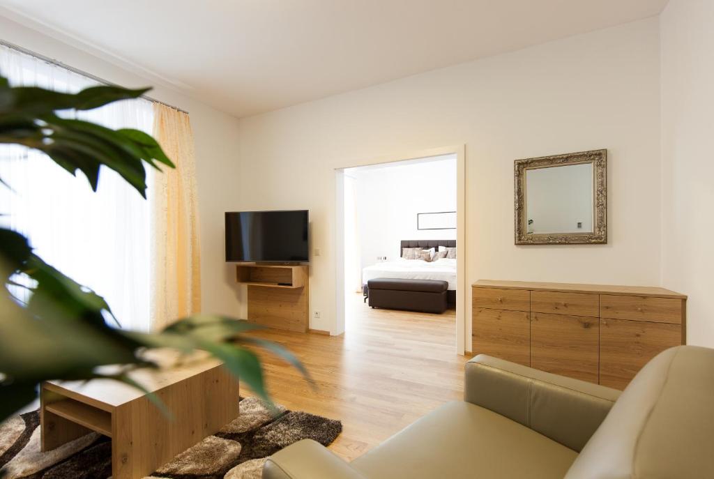 ein Wohnzimmer mit einem Sofa und einem TV in der Unterkunft Nadland Apartment Wehlistrasse in Wien