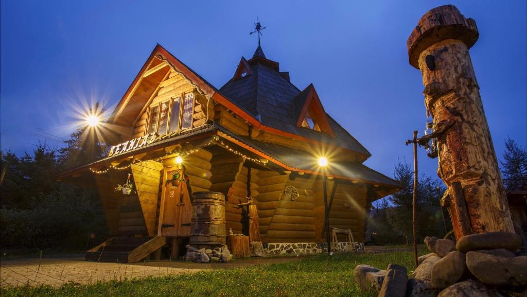 una cabaña de madera con luces en la parte delantera en Vedmid, en Ludvikuvka
