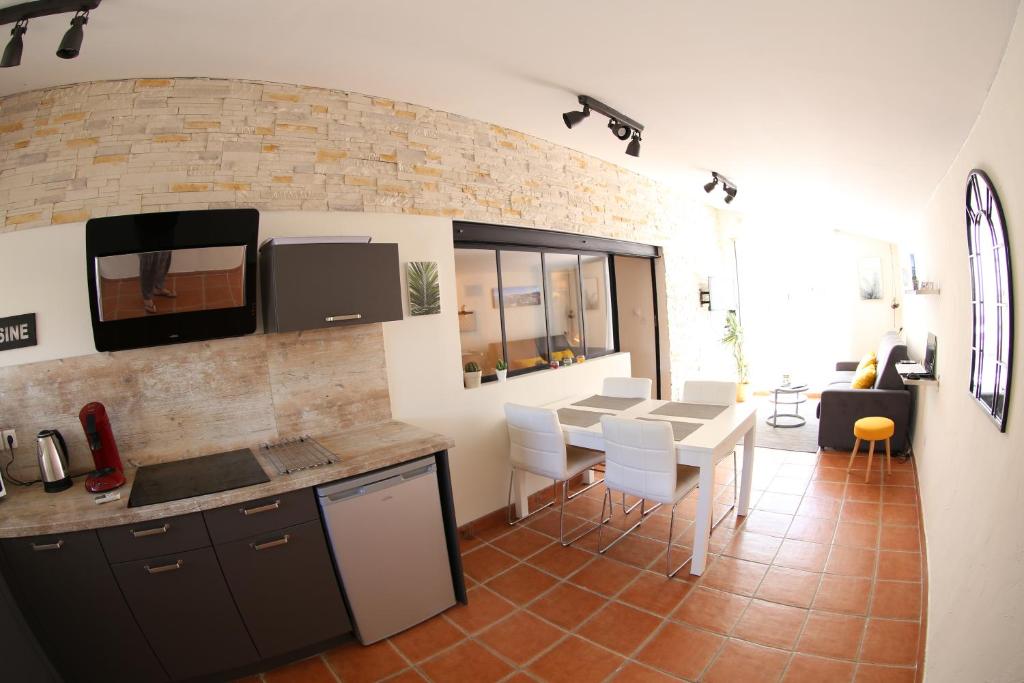- une cuisine et une salle à manger avec une table et des chaises dans l'établissement appart central et son parking privatif gratuit, à Collioure