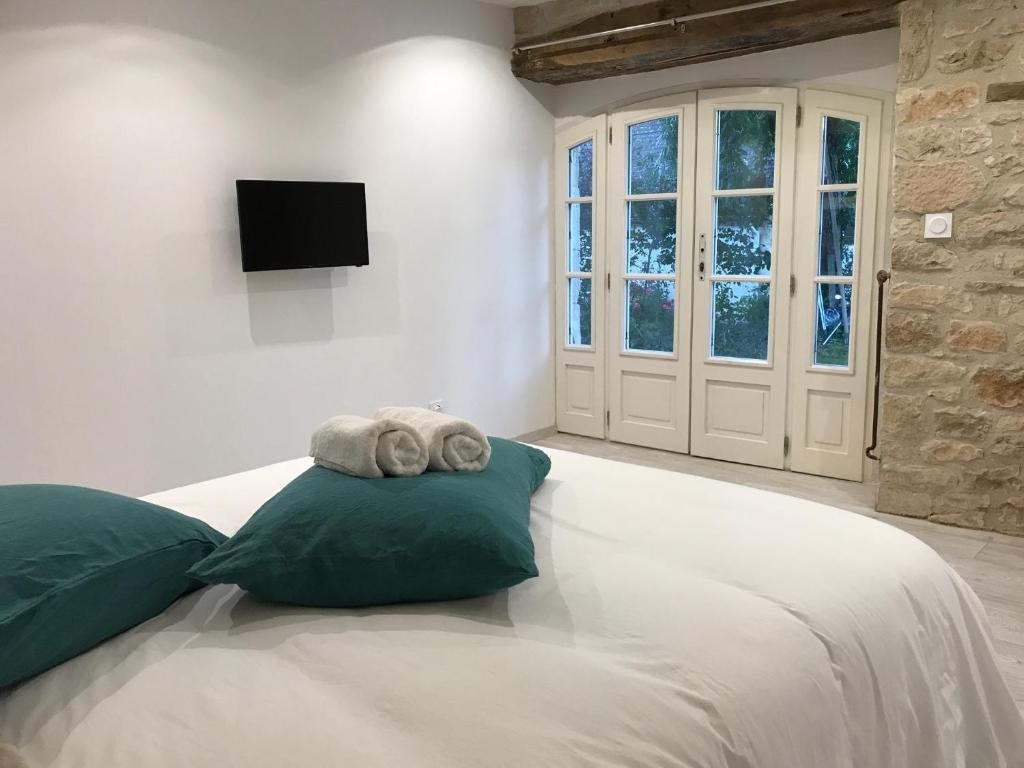 a bedroom with a large white bed with two pillows at Les Mandarins in Baladou