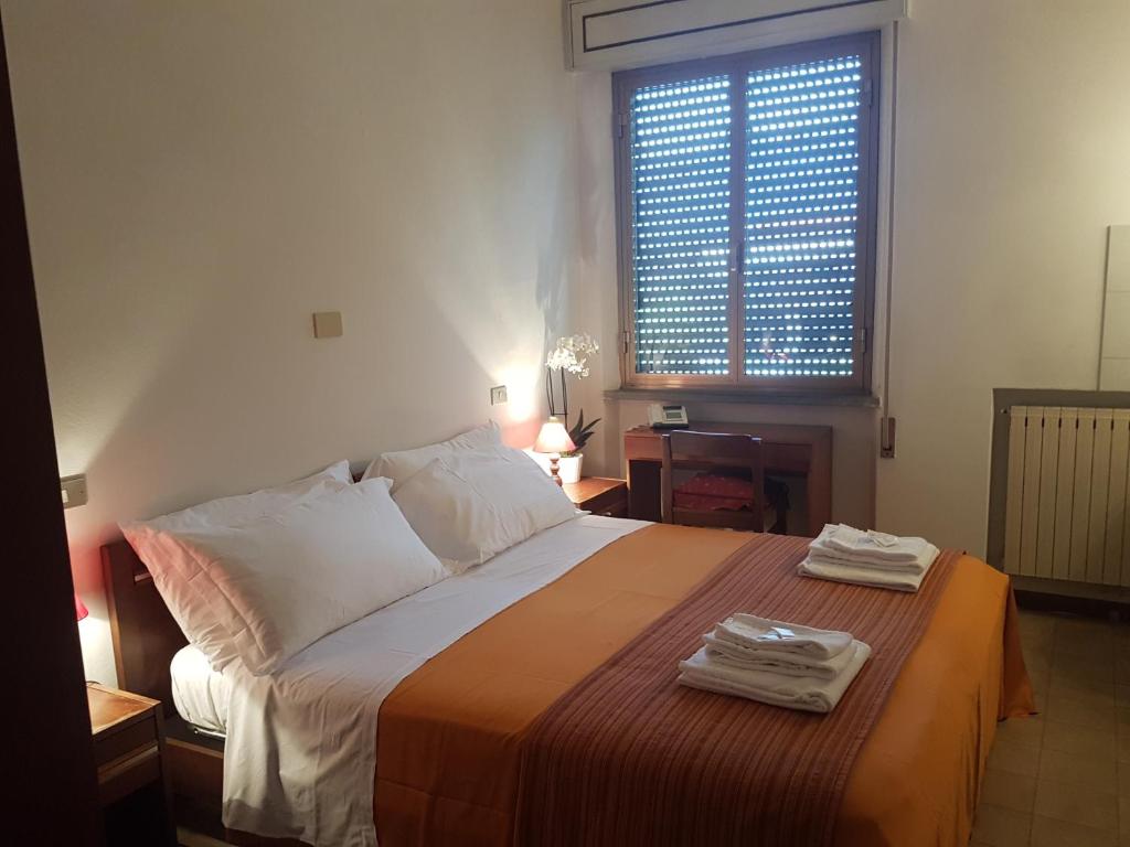 a bedroom with a large bed with two towels on it at Albergo Smeraldo in Castelnuovo Magra