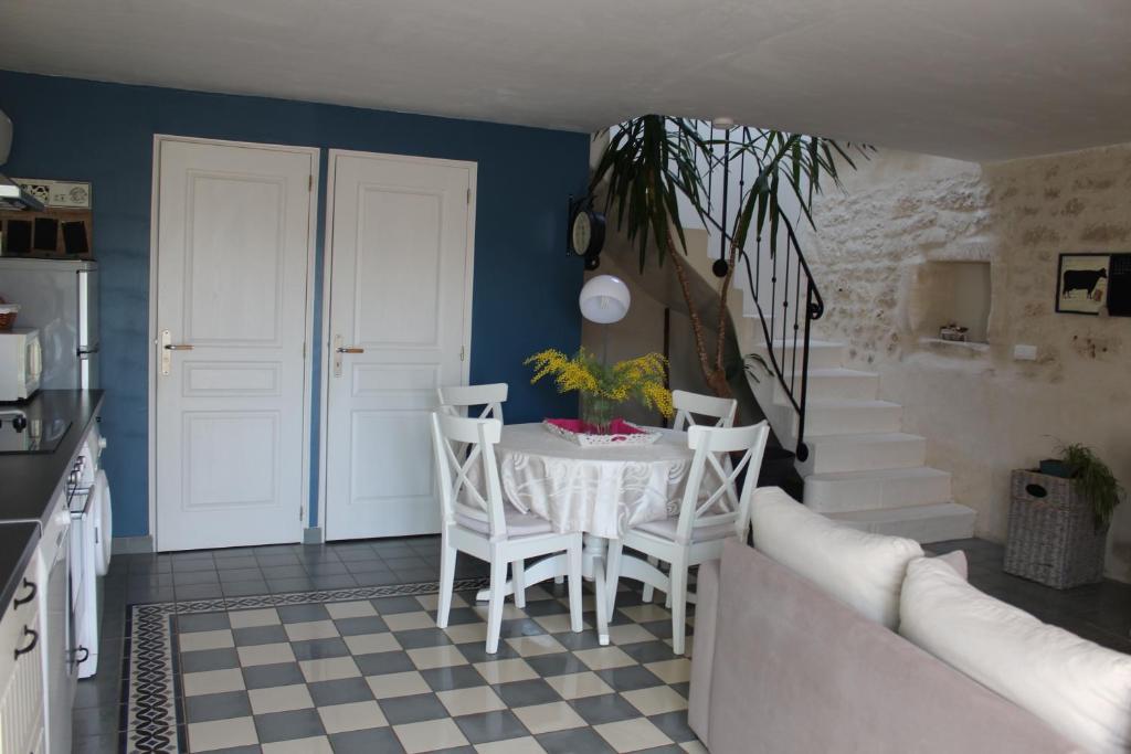 une salle à manger avec une table et des chaises blanches dans l'établissement Les gîtes du veau d'or, à Ozillac