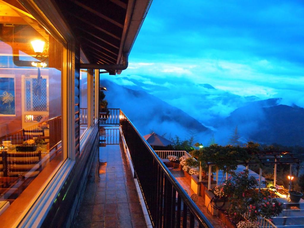 een balkon van een gebouw met uitzicht op de bergen bij 5 KM Villa in Renai