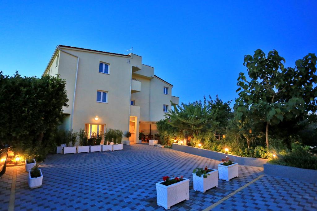 un edificio con patio por la noche en Apartments & rooms Stella Adriatica, en Murter