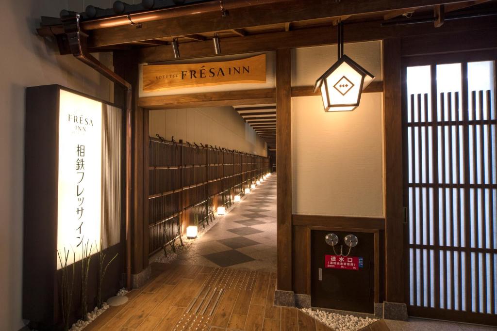 un pasillo en un edificio con un cartel que lee el firstuminati en Sotetsu Fresa Inn Kyoto-Shijokarasuma, en Kioto