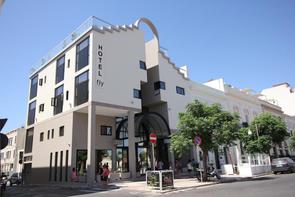 a large white building on a city street at Hotel Fly in Gallipoli