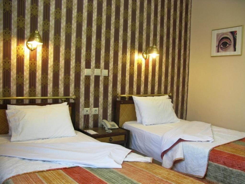 Postel nebo postele na pokoji v ubytování Olympos Hotel