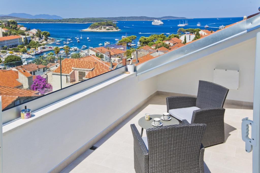 uma varanda com mesa e cadeiras e vista para o oceano em Apartments Juric em Hvar