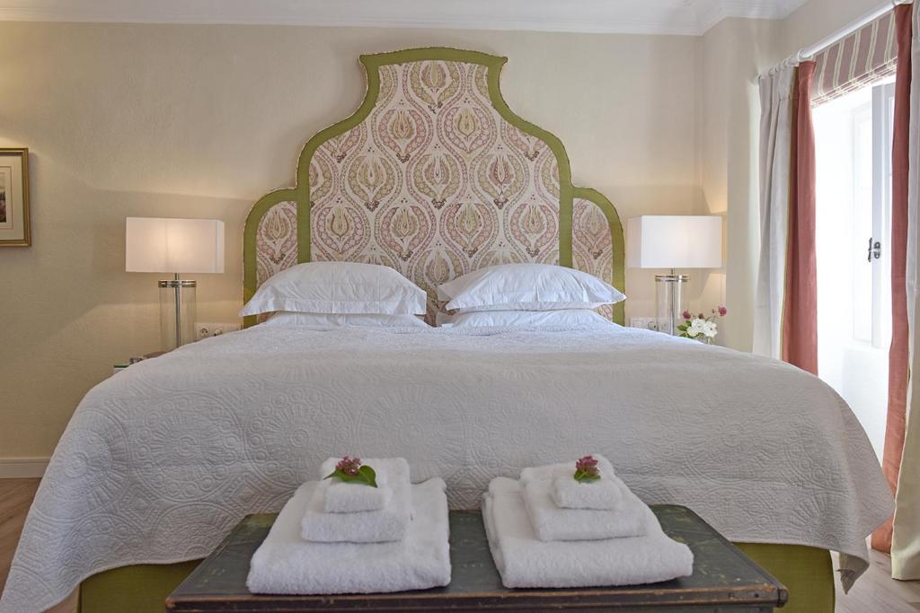 a bedroom with a large bed with two towels at Achillion Liston Suites in Corfu
