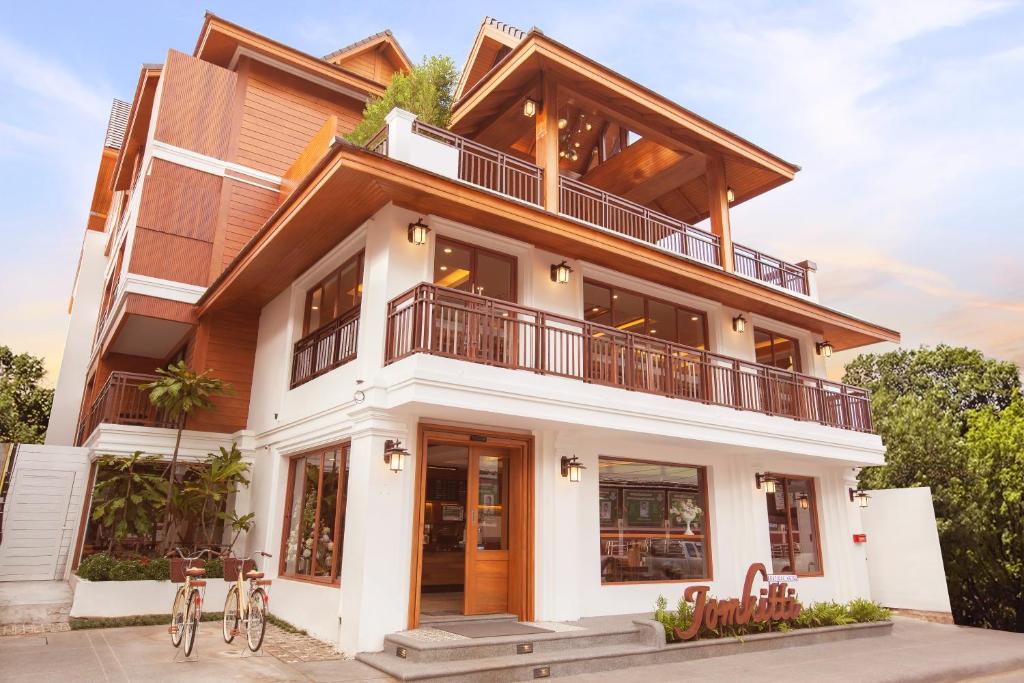 una casa con un balcón encima en Jomkitti Boutique Hotel, en Chiang Mai
