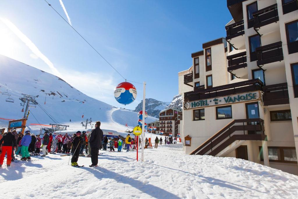 un grupo de personas de pie en la nieve en una pista de esquí en Hôtel La Vanoise, en Tignes