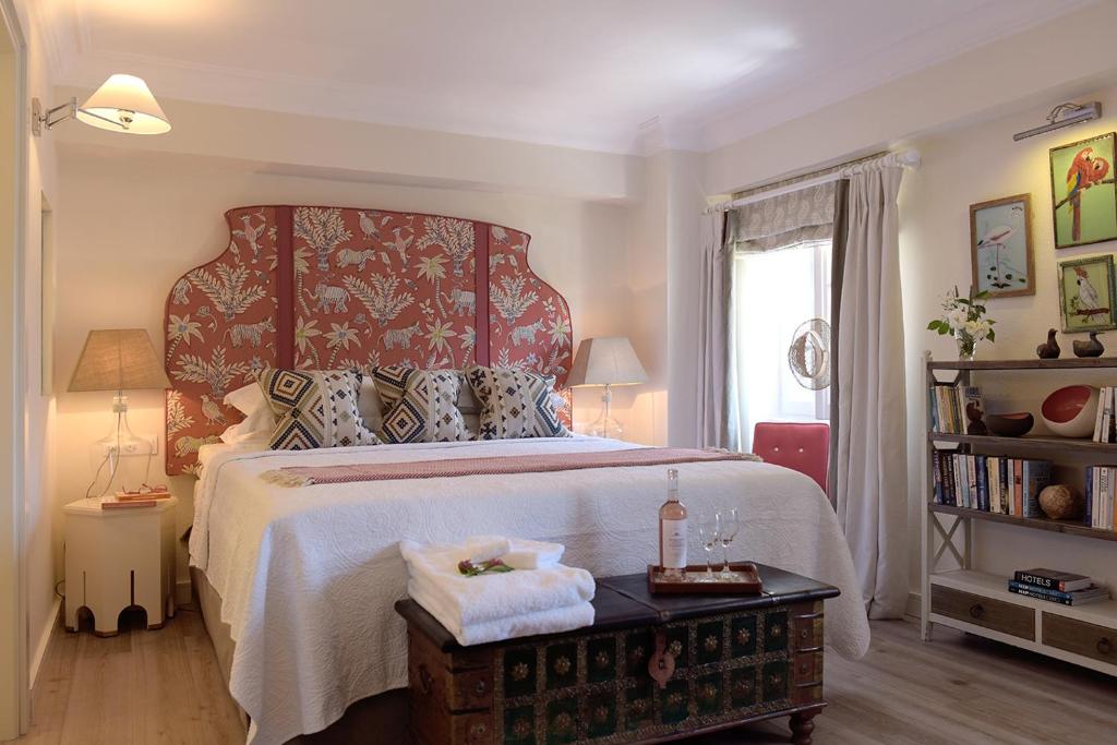 a bedroom with a large bed with a red headboard at Durrell Liston Suites in Corfu Town