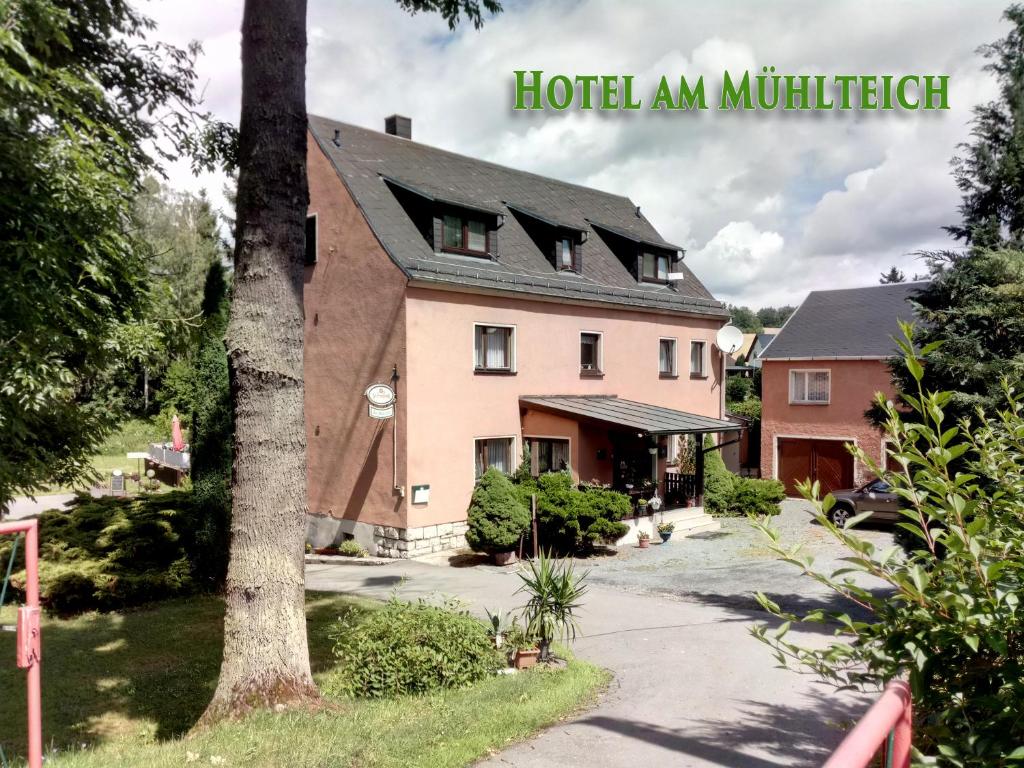 a large pink house with a black roof at Am Mühlteich in Taltitz