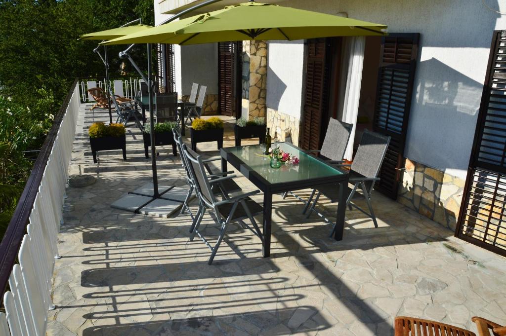 stół i krzesła z parasolem na patio w obiekcie Apartments Martina w mieście Nijvice