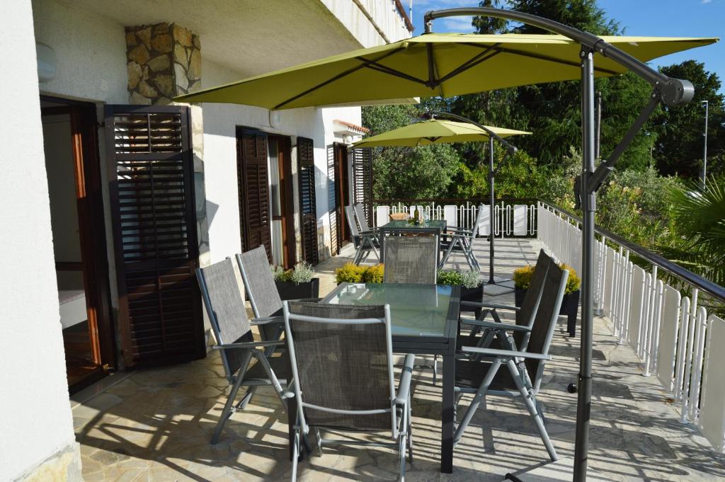 stół i krzesła pod parasolem na patio w obiekcie Apartments Martina w mieście Nijvice