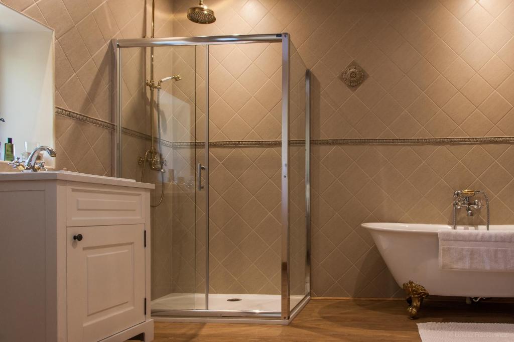 La salle de bains est pourvue d&#39;une douche, d&#39;une baignoire et d&#39;un lavabo. dans l&#39;établissement Château Rieutort Gîtes, à Saint-Pargoire