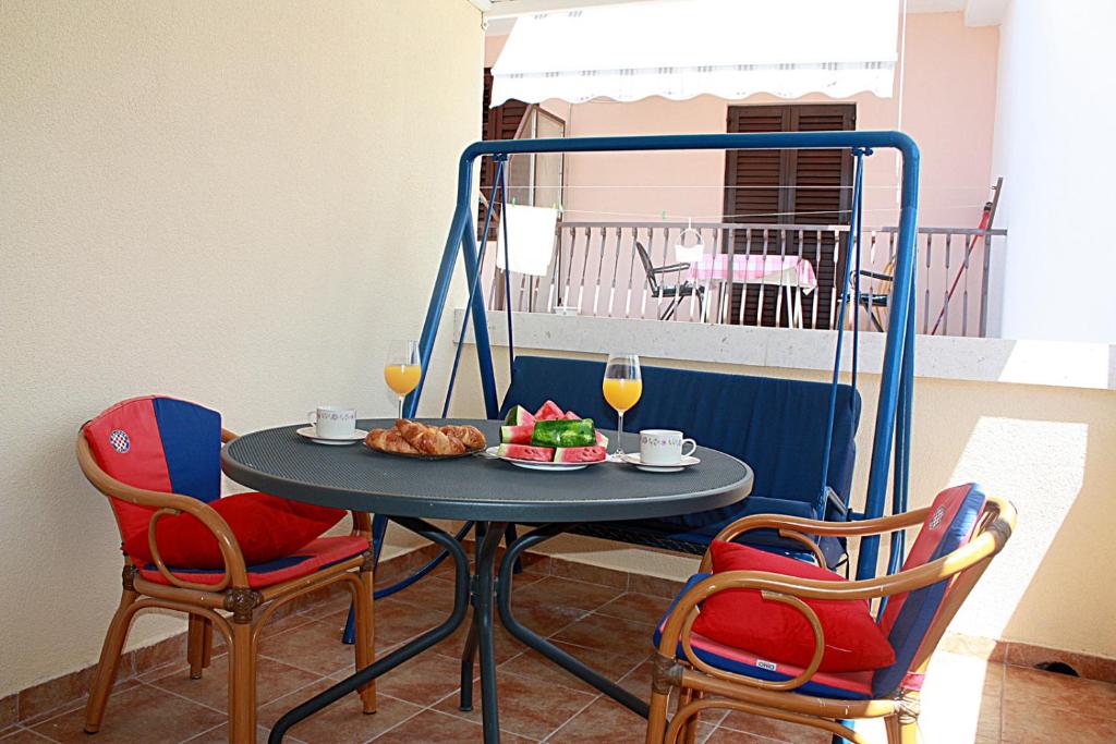 a table with a plate of food and two chairs at Apartment Tomislav in Zaostrog