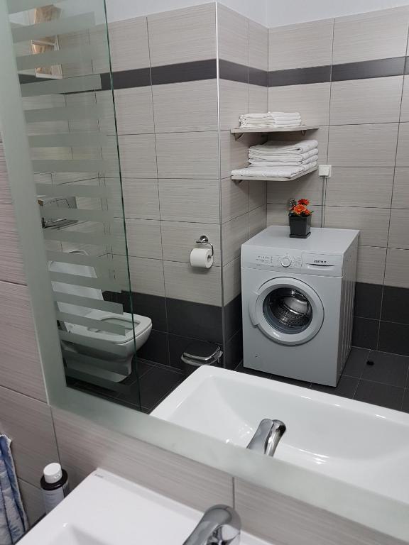 łazienka z umywalką i pralką w obiekcie Bourlis Apartments w mieście Asprovalta