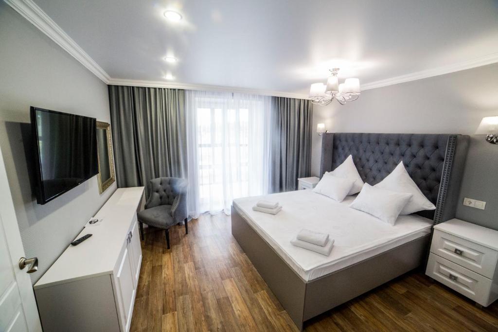 a hotel room with a bed and a television at KvartHaus on 40 Let Pobedy in Tolyatti