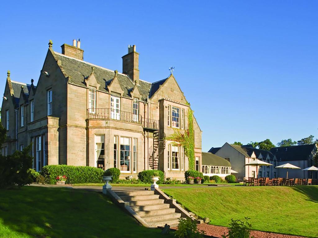 une grande maison avec une pelouse devant elle dans l'établissement Norton House Hotel & Spa, Edinburgh, à Ingliston