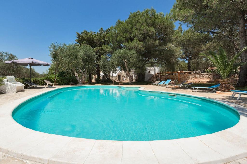 una piscina in un cortile alberato di Villa Ricci by BarbarHouse a Ceglie Messapica
