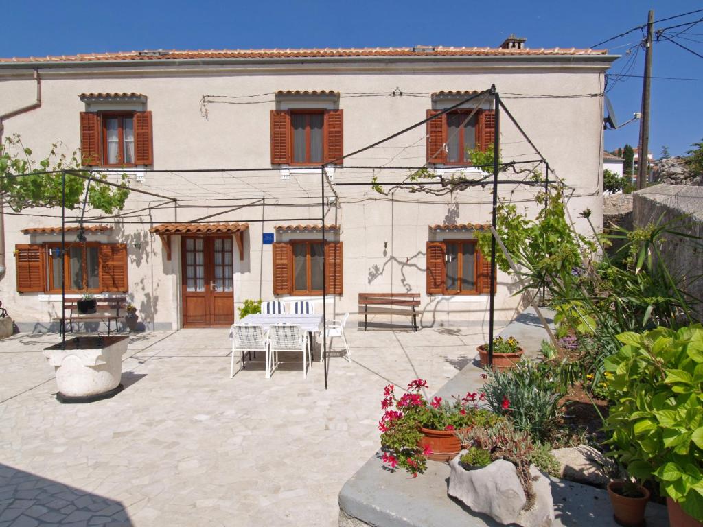 a house with a courtyard with a table and chairs at Armida in Veli Lošinj