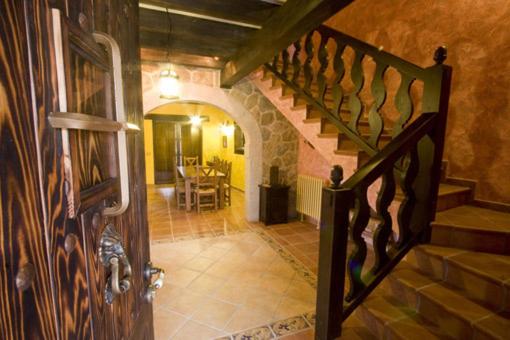 a hallway with a wooden door and a staircase at Casas Herrenales de Ulaca in Solosancho