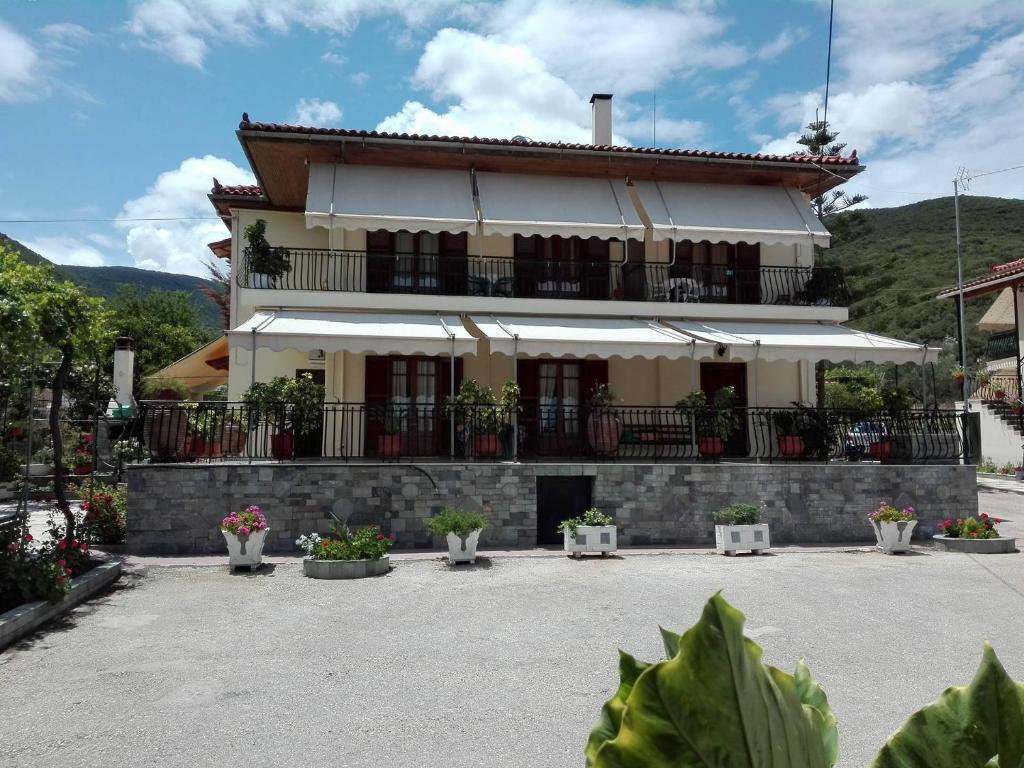 un edificio con balcone e piante in un cortile di Toulatos Pantelis a Pouláta