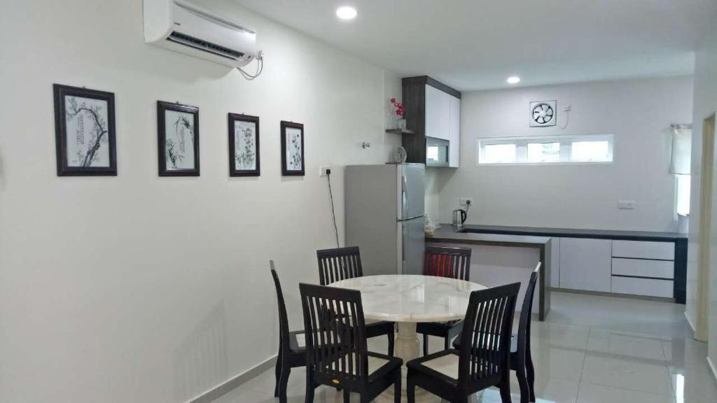 a kitchen with a table and chairs and a refrigerator at Pangkor Holiday Home in Pangkor