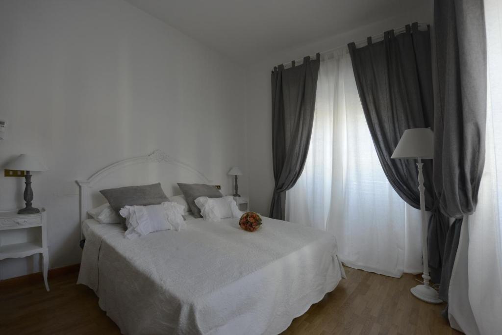 a bedroom with a white bed and a window at Appartamento Irene in Pisa