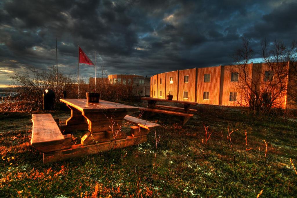 ein Picknicktisch und ein Gebäude mit einer roten Flagge in der Unterkunft Thon Hotel Kautokeino in Kautokeino