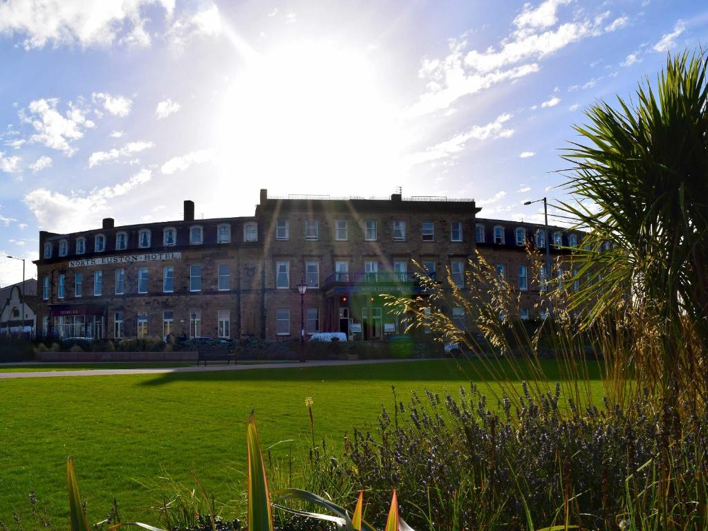 un gran edificio de ladrillo con el sol en el cielo en The North Euston Hotel, en Fleetwood