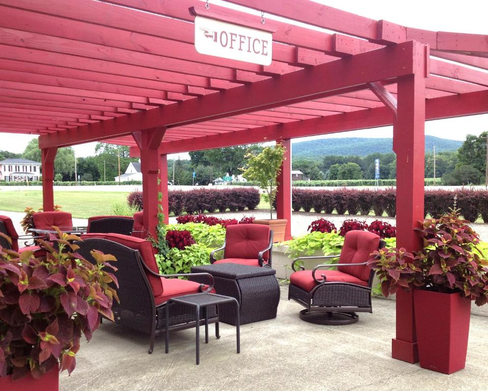 a patio with chairs and a pergola at Vinehurst Inn & Suites in Hammondsport