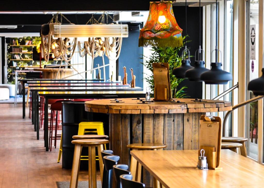 um bar com mesas e cadeiras de madeira num restaurante em Generator Copenhagen em Copenhague