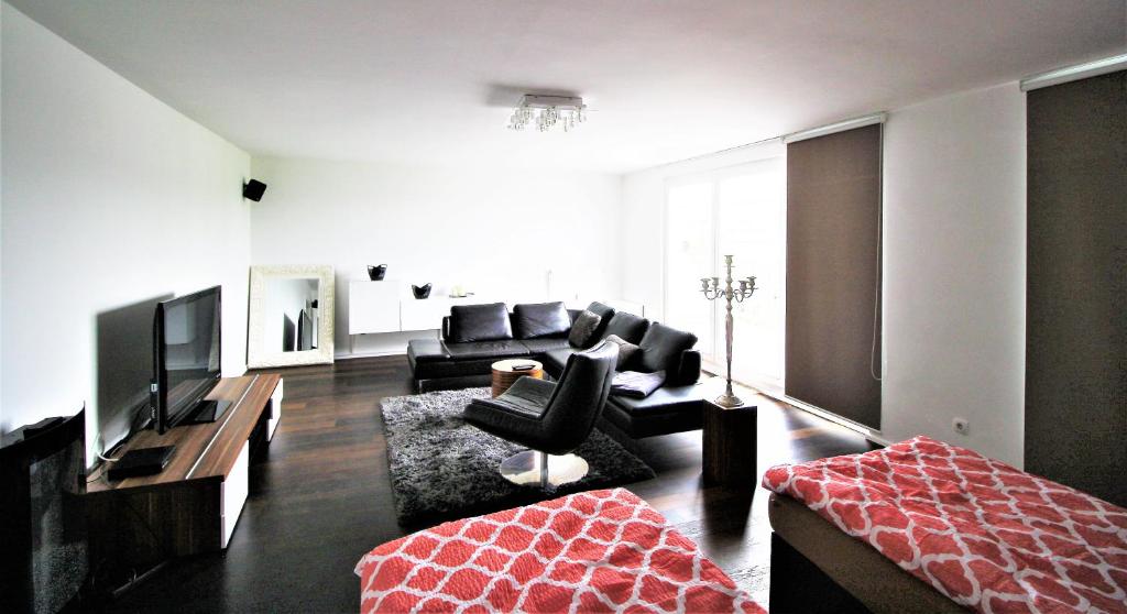a living room with a couch and a television at Dorya am Ring in Cologne
